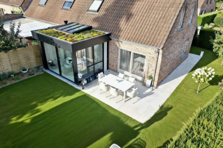 Extension moderne avec toiture végétalisée en sedum et bande de graviers autour du puits de lumière sur maison en brique